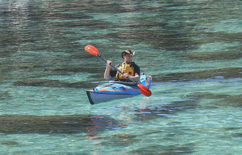 image of a man riding a drop stitch kayak