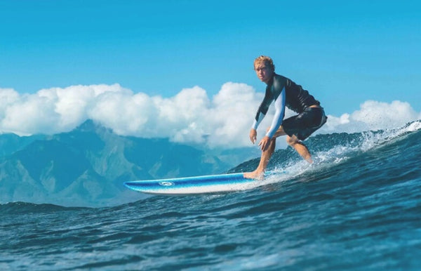 A man surfing on a foam longboard