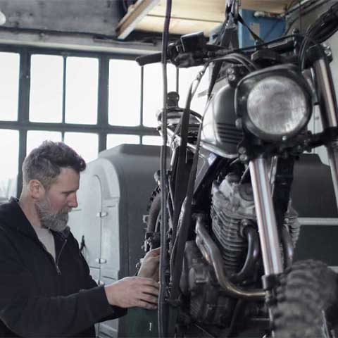 man fixing motorcycle