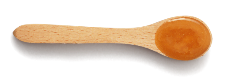 Wooden spoon with honey on a white background.