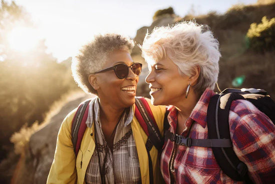 The health benefits of strong relationships: an active retired friends laughing together while hiking outdoors in the morning.