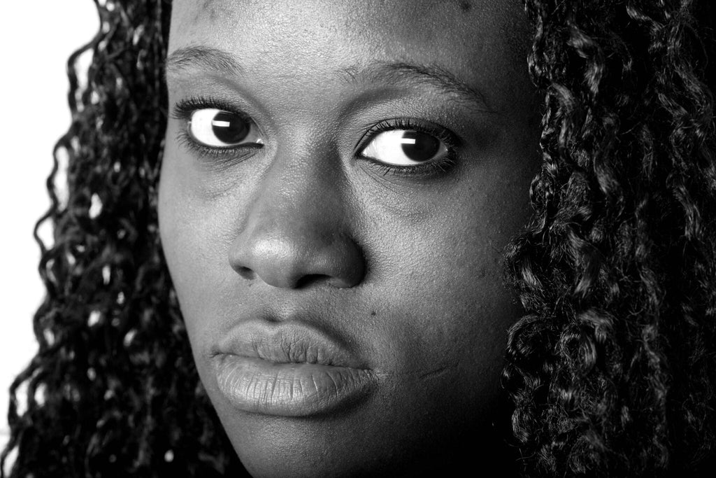 Black and white close up photo of a black woman's face for an article on racism and depression.