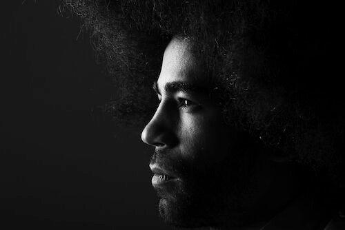 Photo for article on racism and depression. A young male with a gigantic afro stares intensely to the left of the shot.