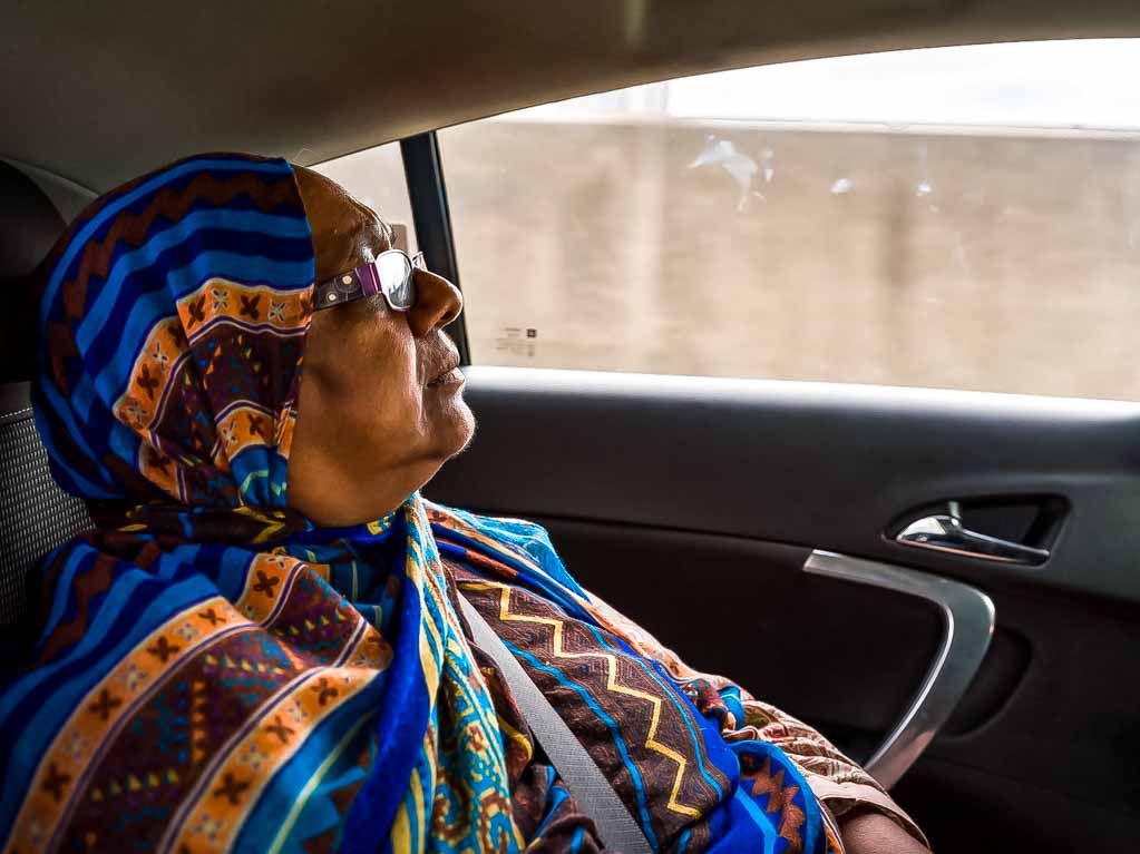 Photo of Sarifa Patel for an article on being a disabled parent. Sarifa is in the backseat of a car looking out the window.