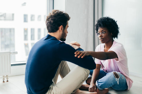 How to handle uncomfortable conversations: a coupe sit on the floor looking at each other.