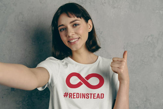 A photo of a person wearing a #RedInstead t-shirt. #RedInstead being one of the phrases promoted during Autism Acceptance Month.