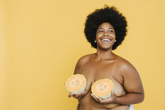Photo for article on breast cancer awareness campaigns. Fat person with cool afro holds two melons over their breasts.