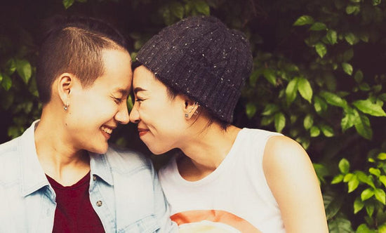 Two woman smile at each other foreheads touching. Image for an article on chronic pain and relationships.