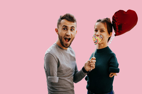 Dating someone with ocd: a man and woman are both smiling at the camera standing against a  pink background.