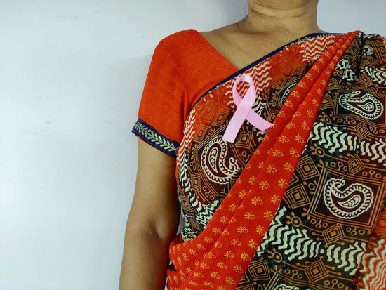 Breast cancer awareness campaigns: a woman wearing a sari has a pink ribbon on her right breast
