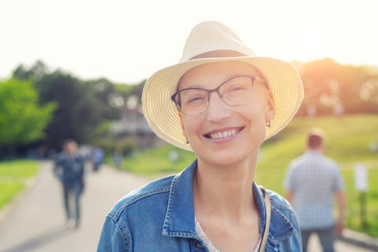 How cancer can shape your life: a happy young caucasian bald woman in hat and casual clothes enjoying life after having breast cancer. 