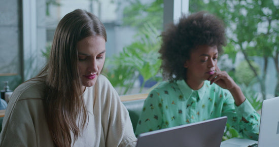 Empathy for chronic illness struggles: photo of two women in front of laptop computers working