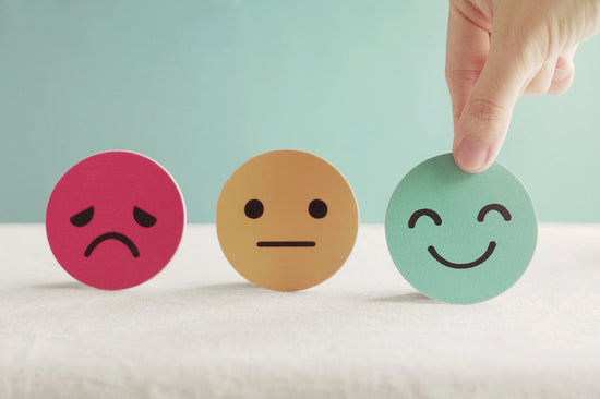Employers need to prioritize employee mental health: a photo of a hand choosing a happy emoji 