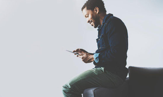 Flexible work arrangements for chronic illness: a photo of a man sitting on a sofa using a tablet