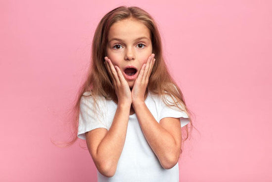 Close up portrait of a surprised child with hand on face on pink background. She is reacting to the question being asked of a disabled person: 