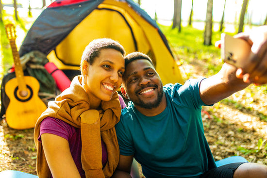 How to help a friend dying of cancer. Photo of a two friends outside camping. They are smiling while one person takes a selfie.