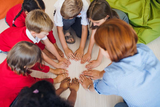 Is there such thing as a typical child? This is color photo of a diverse group of primary school children sitting in a circle with their teacher. They all have different colored hair and skin.