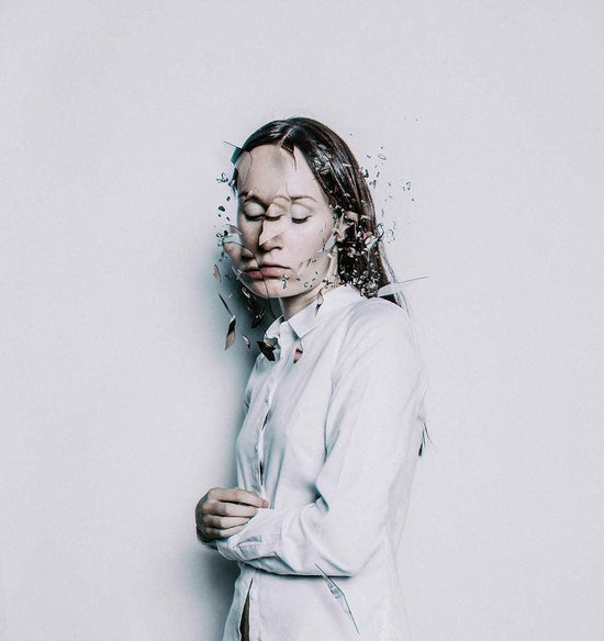 Unbearable pain: photo manipulation of a woman in a white shirt and long hair. Her face is distorted like shattered glass to convey that she is in severe chronic pain.