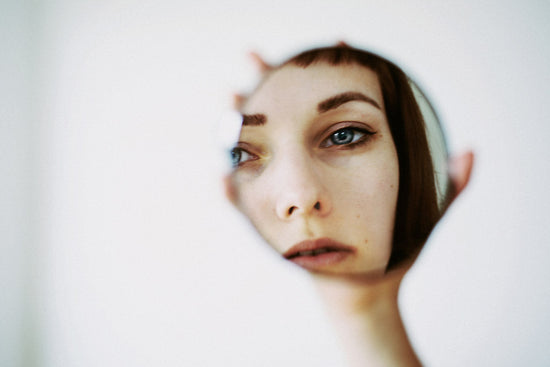 A woman with an eating disorder stares at a mirror reflecting on her use of pro ana sites