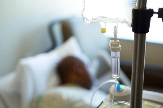 Photo of an African-American person in a hospital bed with an IV drip. Image for an article on racism in US healthcare system