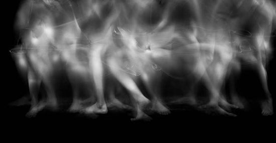 Restless legs syndrome is ruining my life: an abstract black and white photo of a ten pairs of legs, all burred, visible from the hips down, depicting the constant movement of restless leg syndrome and insomnia.