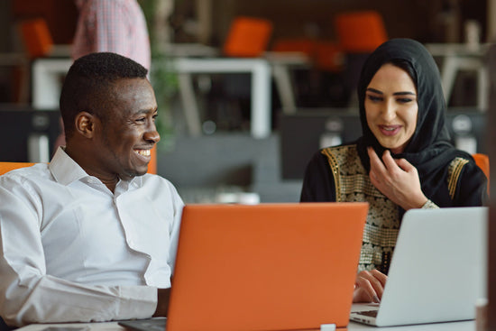 Workplaces need to embrace Neurodiversity: a man and woman are working together at a desk talking about a common workplace issue.