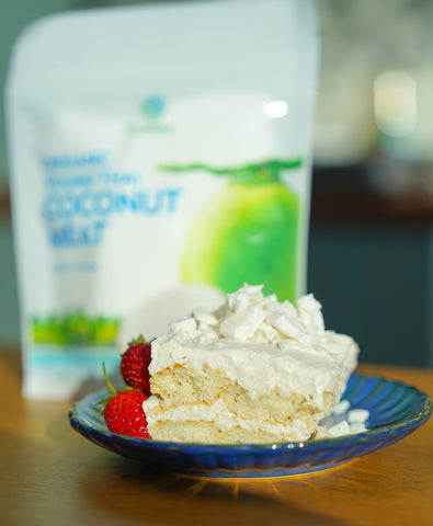Closed up coconut tiramisu served with fresh strawberries and freeze dried coconut meat