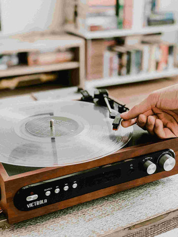 a hand is lifting the needle on a record player
