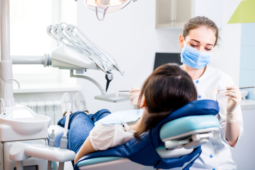 A dentist attending to her patient sitting comfortably in a dental chair