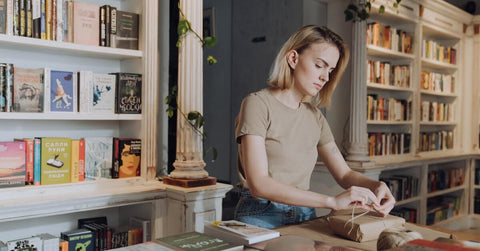 A girl wrapping books.