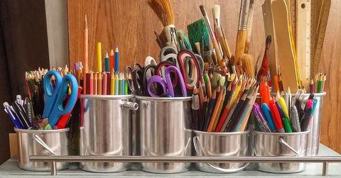 A table full of art supplies as one of the creative gift ideas for your children.