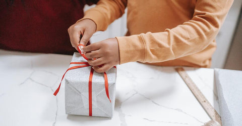 A child opening a wrapped present.