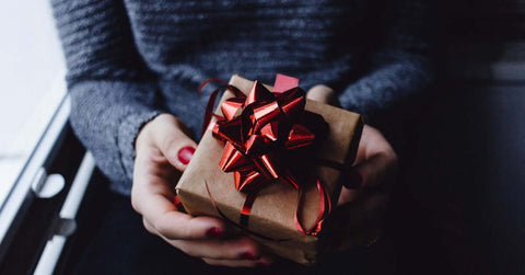 Picture of a person holding a wrapped gift.