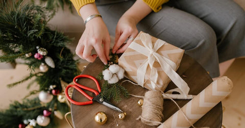 person wrapping up present depicts re-gifting etiquette 