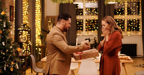 A man giving a woman two presents in boxes.