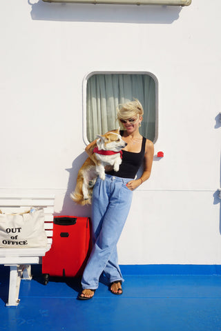 Femme posant avec son chien sur un bateau de croisière fluviale