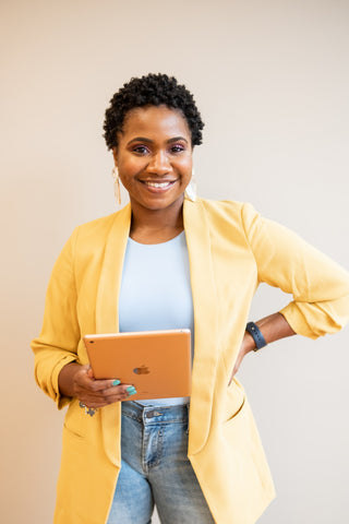 Happy woman wearing yellow blazer with jeans