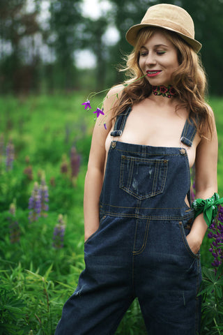 Jeune femme posant avec une salopette en jean