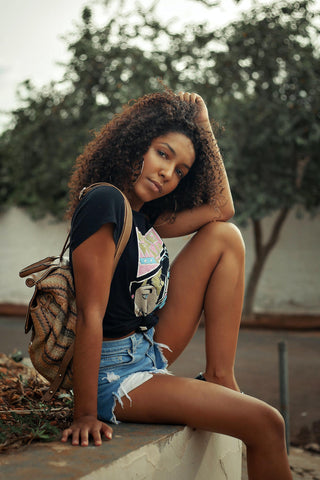 Black girl posing in denim shorts and graphic tee