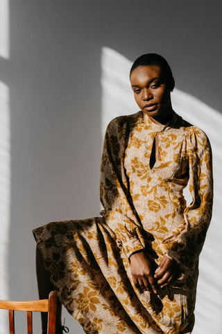 Black woman posing with a Western floral dress