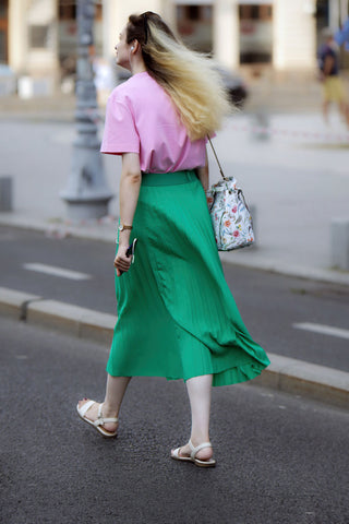 Femme portant une jupe midi verte et un t-shirt basique