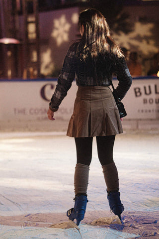 Girl wearing skirt and tights ice skating
