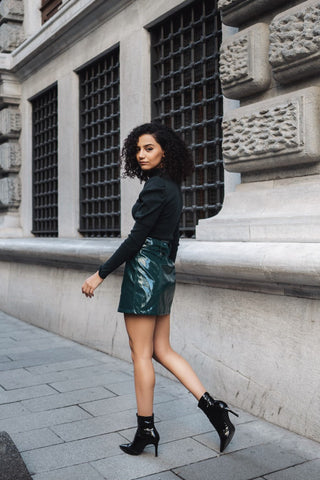 woman wearing shiny mini skirt and ankle boots