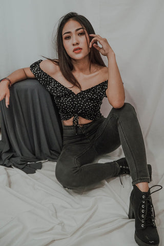 Girl posing with off-the-shoulder top and grey skinny jeans