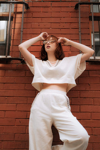 Girl posing with a white crop top and wide-leg pants