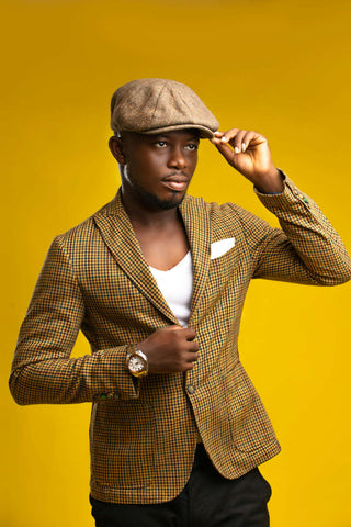 Man posing with a retro-inspired blazer and a hat