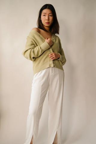Woman posing for photo wearing a cardigan and wide-leg pants