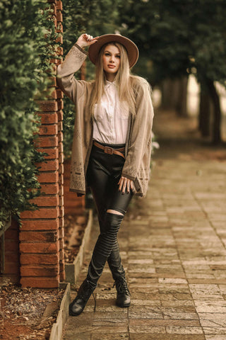Woman posing with a long cardigan over leather pants and a shirt