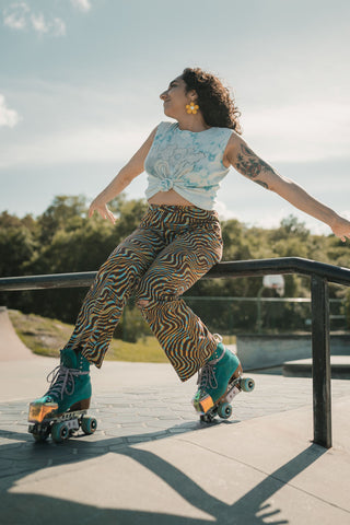 Woman posing with roller skates wearing retro-inspired flared pants