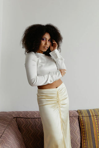 Woman posing with a champagne satin skirt and a white blouse